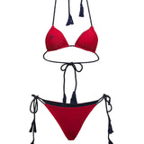 Deep red string bikini set with black straps and tassels on a white background