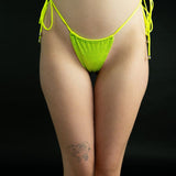 Model posing stylishly in lime green designer strappy bikini