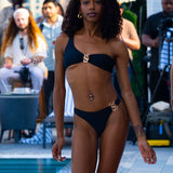 Full-length front view of an athletic model wearing the SBOVIA Nero Classico black single-shoulder bikini set with custom luxury metallic hardware